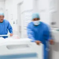 picture of nurses in OT uniforms and a hospital bed